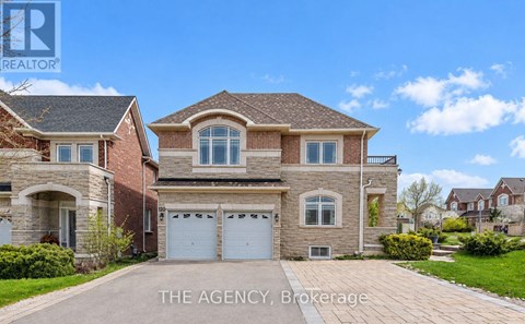 A large, two-story house with a brick facade and a driveway in front.