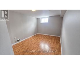 A room with wooden flooring and a window.
