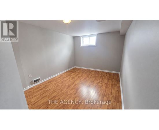 A room with wooden flooring and a window.