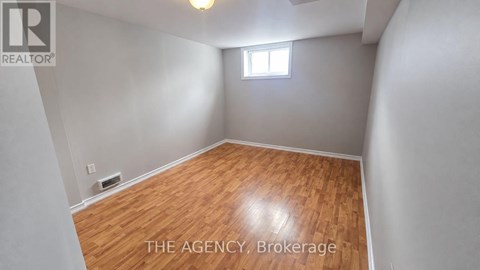 A room with wooden flooring and a window.