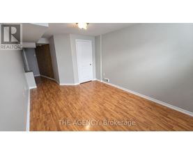 A room with wooden flooring and a white door.