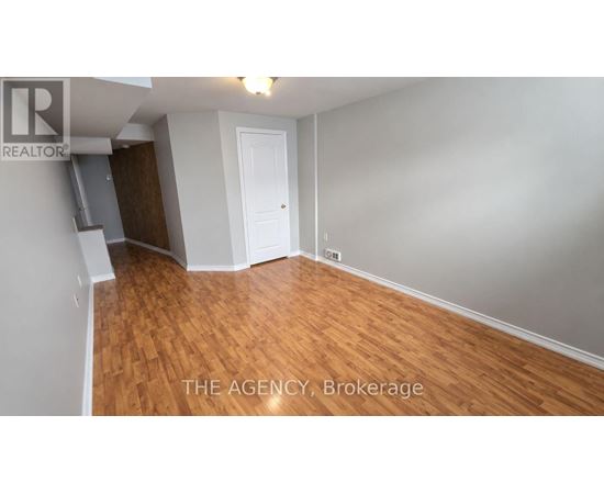A room with wooden flooring and a white door.