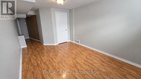 A room with wooden flooring and a white door.