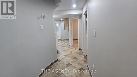 A hallway with a tiled floor and white walls.