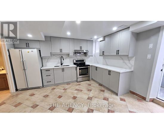 A kitchen with white cabinets and a tiled floor.