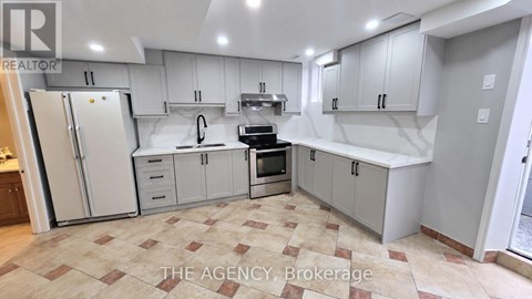 A kitchen with white cabinets and a tiled floor.