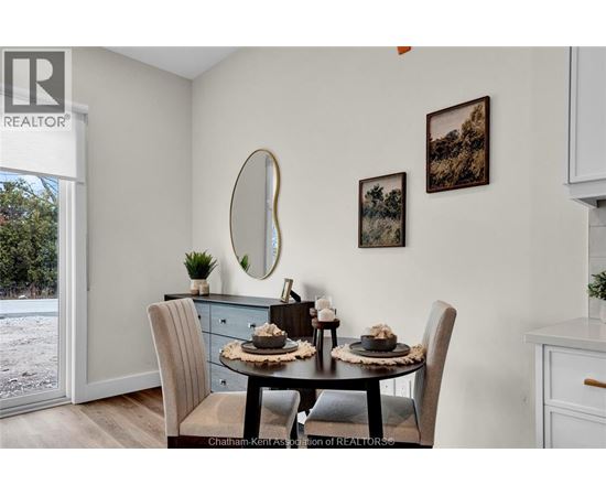 A dining room with a table set for two and a view of a snowy landscape outside.