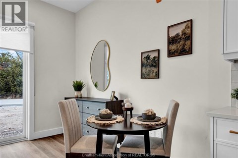 A dining room with a table set for two and a view of a snowy landscape outside.