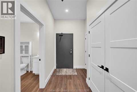 A hallway with a black door and white walls.