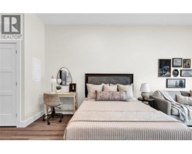 A bedroom with a large bed and a desk with a chair.