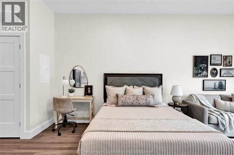 A bedroom with a large bed and a desk with a chair.