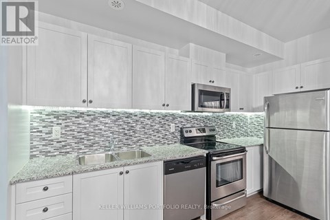 A kitchen with white cabinets and a granite countertop.