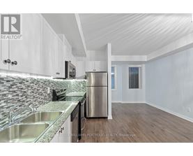 A kitchen with white cabinets and a stainless steel refrigerator.