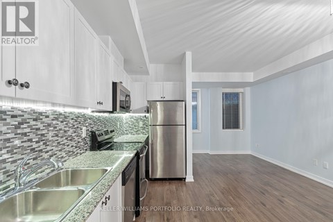 A kitchen with white cabinets and a stainless steel refrigerator.