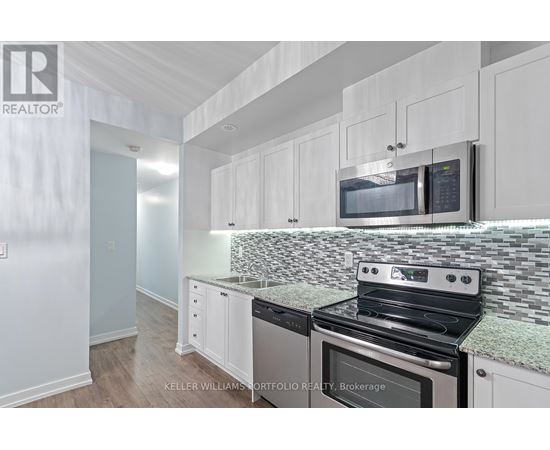A kitchen with white cabinets and a black stove top oven.