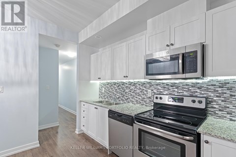 A kitchen with white cabinets and a black stove top oven.