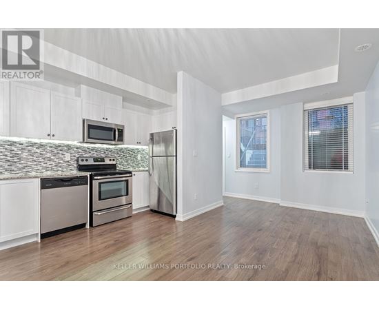 A kitchen with white cabinets and a tiled backsplash.