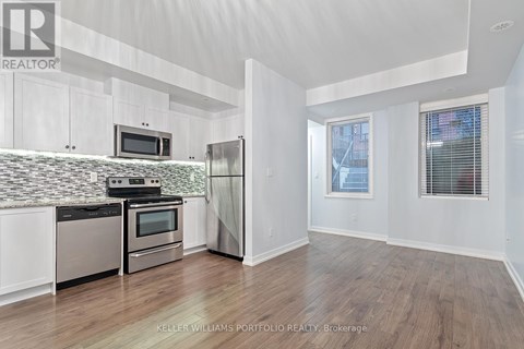 A kitchen with white cabinets and a tiled backsplash.