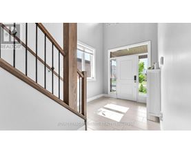 A white interior space with a staircase and a door leading to a balcony.