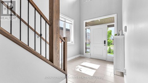 A white interior space with a staircase and a door leading to a balcony.