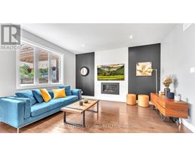 A living room with a blue couch and a fireplace.
