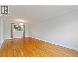A room with wooden flooring and a window with curtains.