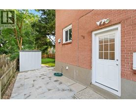 A red brick house with a white door and a small garden area.