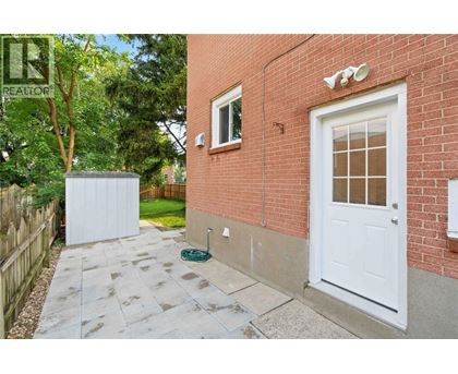 A red brick house with a white door and a small garden area.