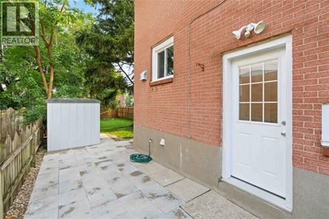 A red brick house with a white door and a small garden area.