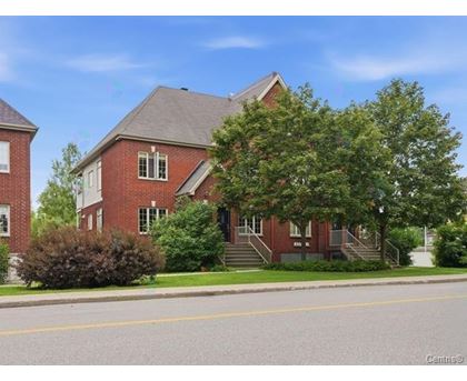A red brick building with a tree in front of it.