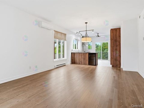 A spacious room with wooden flooring and a large window.
