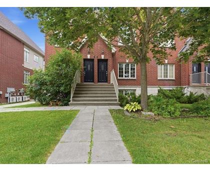 A red brick building with a black door and steps leading up to it.