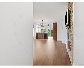 A room with wooden floors and a stone wall with a television mounted on it.