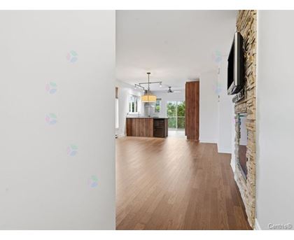 A room with wooden floors and a stone wall with a television mounted on it.