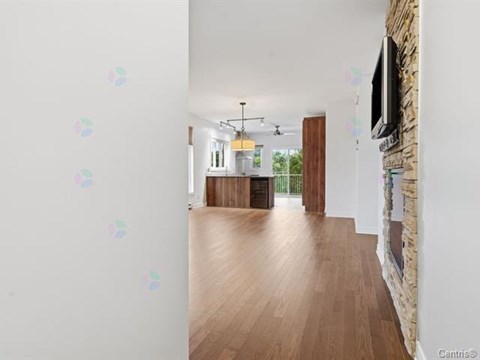 A room with wooden floors and a stone wall with a television mounted on it.