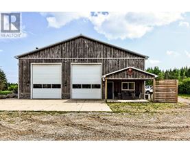 A large wooden barn with two white garage doors.