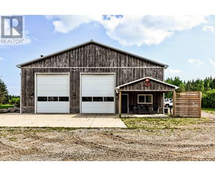 A large wooden barn with two white garage doors.