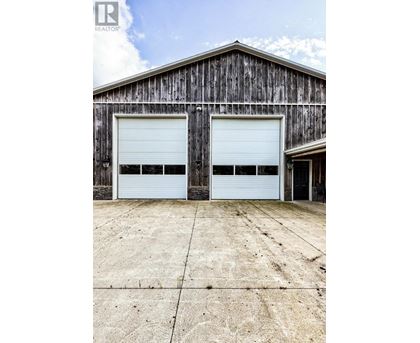 A large wooden building with two white garage doors.