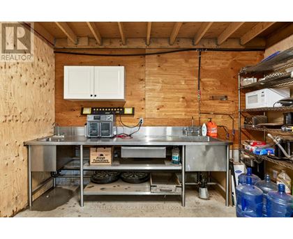 A kitchen area with a stainless steel table and a wooden wall.