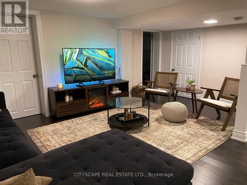 A living room with a television, a fireplace, and a couch.