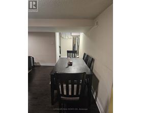 A dining room with a wooden table and chairs.