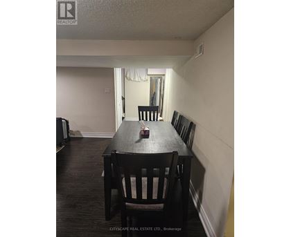 A dining room with a wooden table and chairs.
