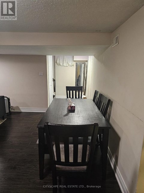 A dining room with a wooden table and chairs.