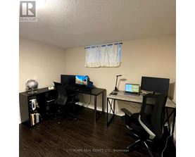 A room with two desks and chairs, one of which is a standing desk.