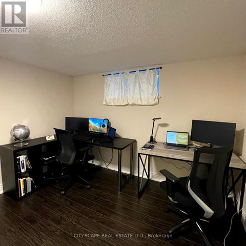 A room with two desks and chairs, one of which is a standing desk.