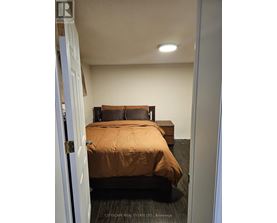 A bedroom with a bed and a bench.