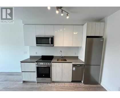 A kitchen with a refrigerator, oven, and microwave.