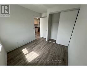 A real estate listing image of a room with wood flooring and white walls.