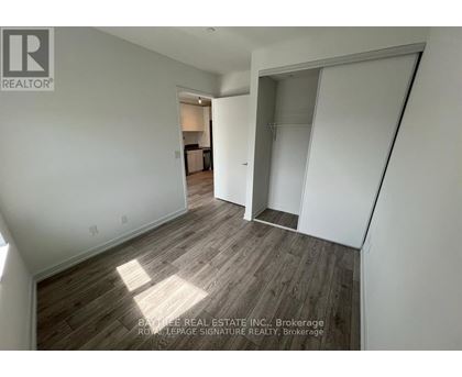 A real estate listing image of a room with wood flooring and white walls.