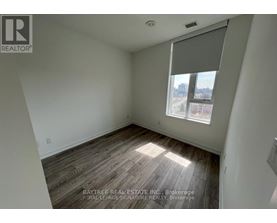 A room with a window and wooden flooring.